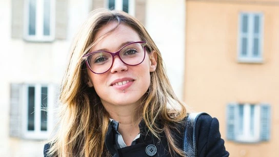 étudiante blonde à lunettes souriant