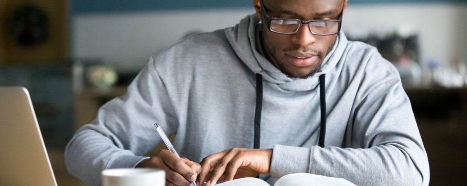 jeune étudiant qui révise à la maison